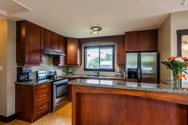 Kitchen with dark wood cabinets and granite counters