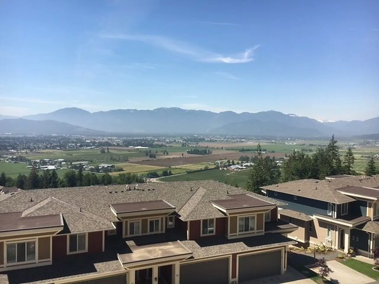 Townhouse rooftops with farmland and mountains beyond