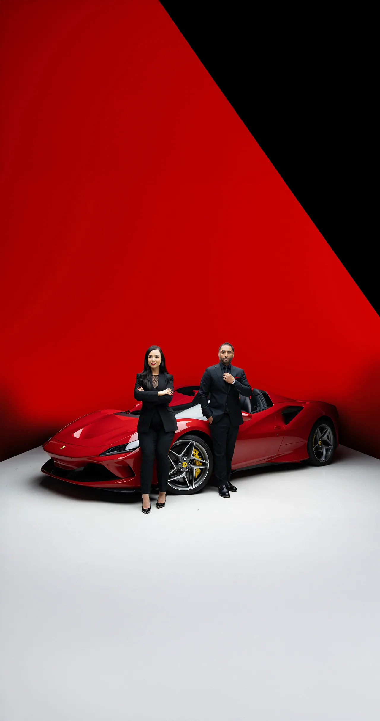 Jas Oberoi and Maria Hussain beside a red sports car in a studio
