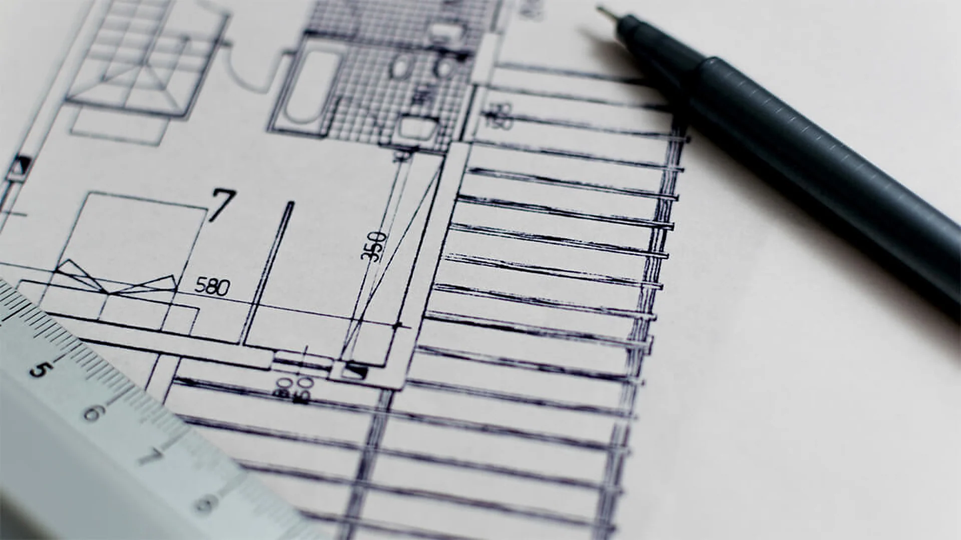 Architectural floor plan drawing with a pen