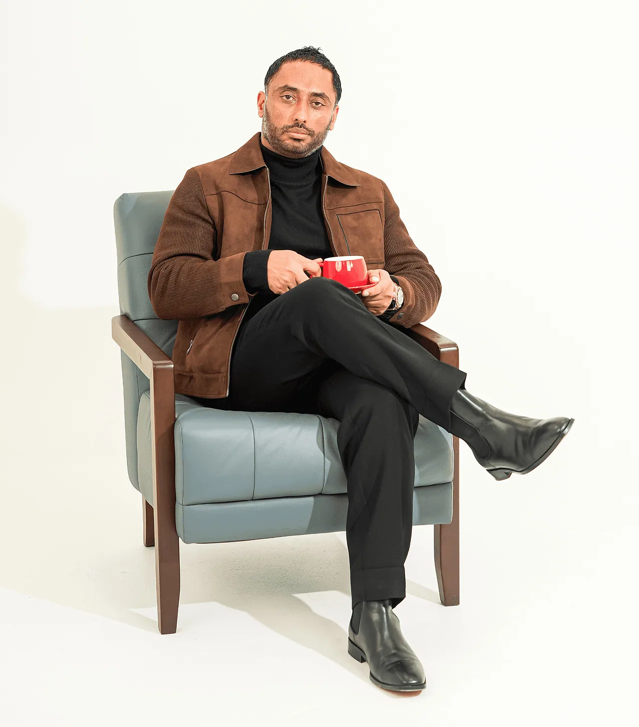 Team member seated in an armchair in a white studio