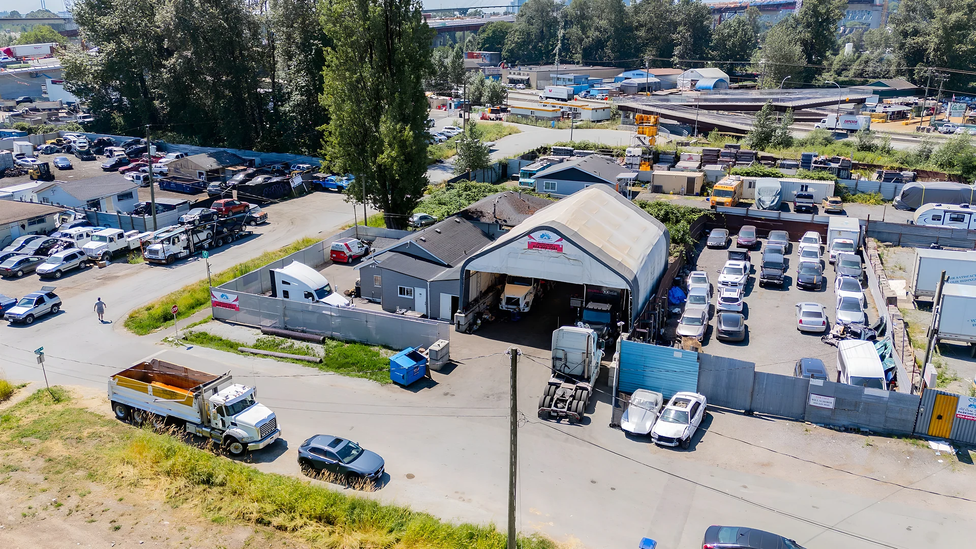 Aerial view of an industrial yard with trucks, vehicles and buildings