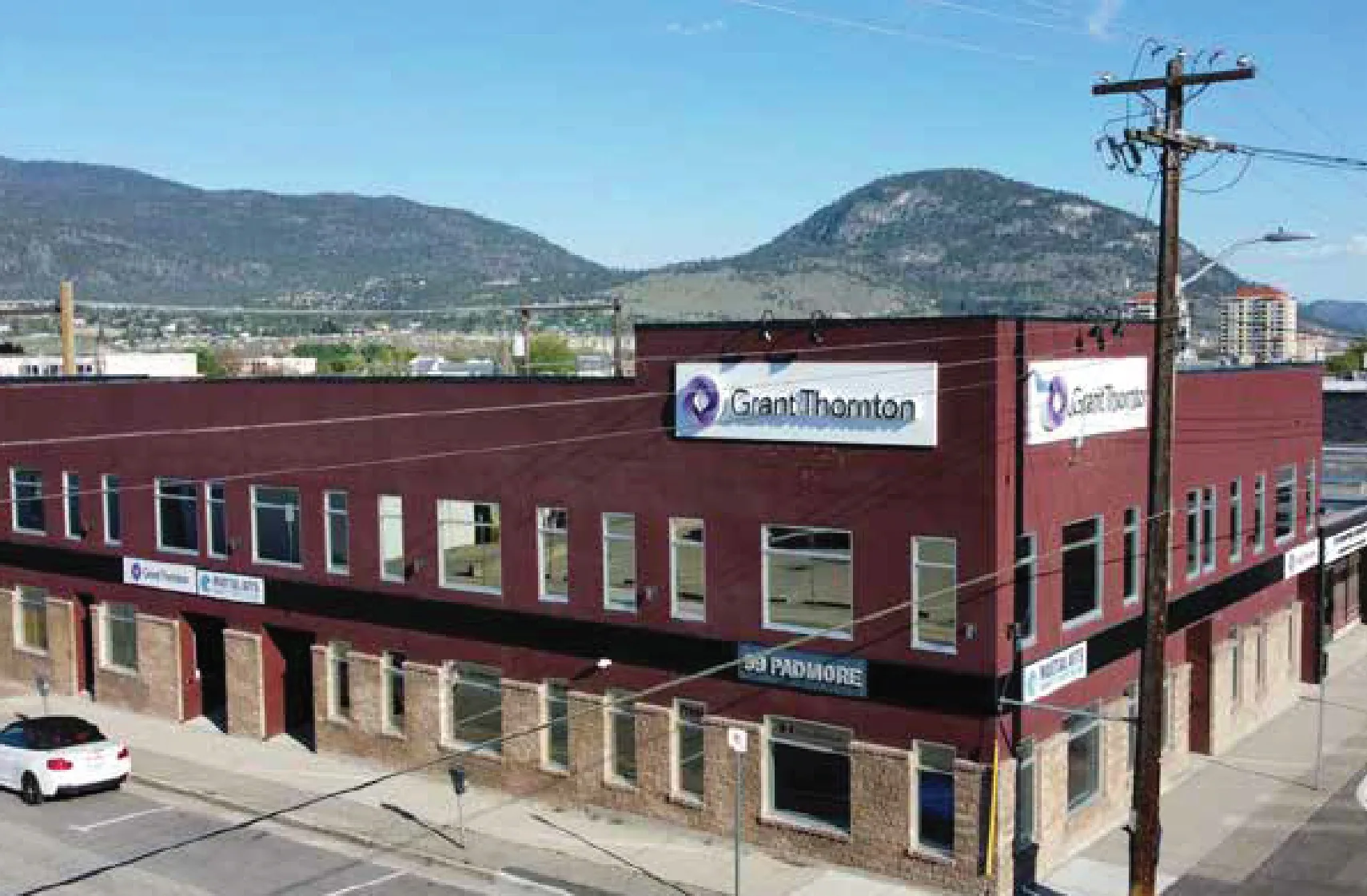 Two-storey red brick office building with Grant Thornton signage on a street corner