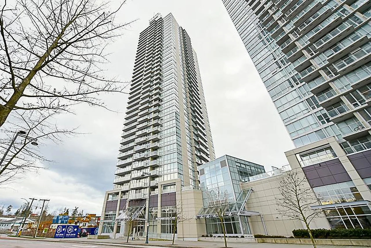 Upward view of tall residential glass tower with adjacent tower and street level below