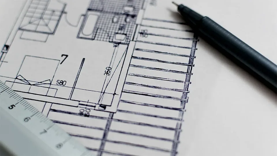 Architectural floor plan on paper with a black pen and a ruler