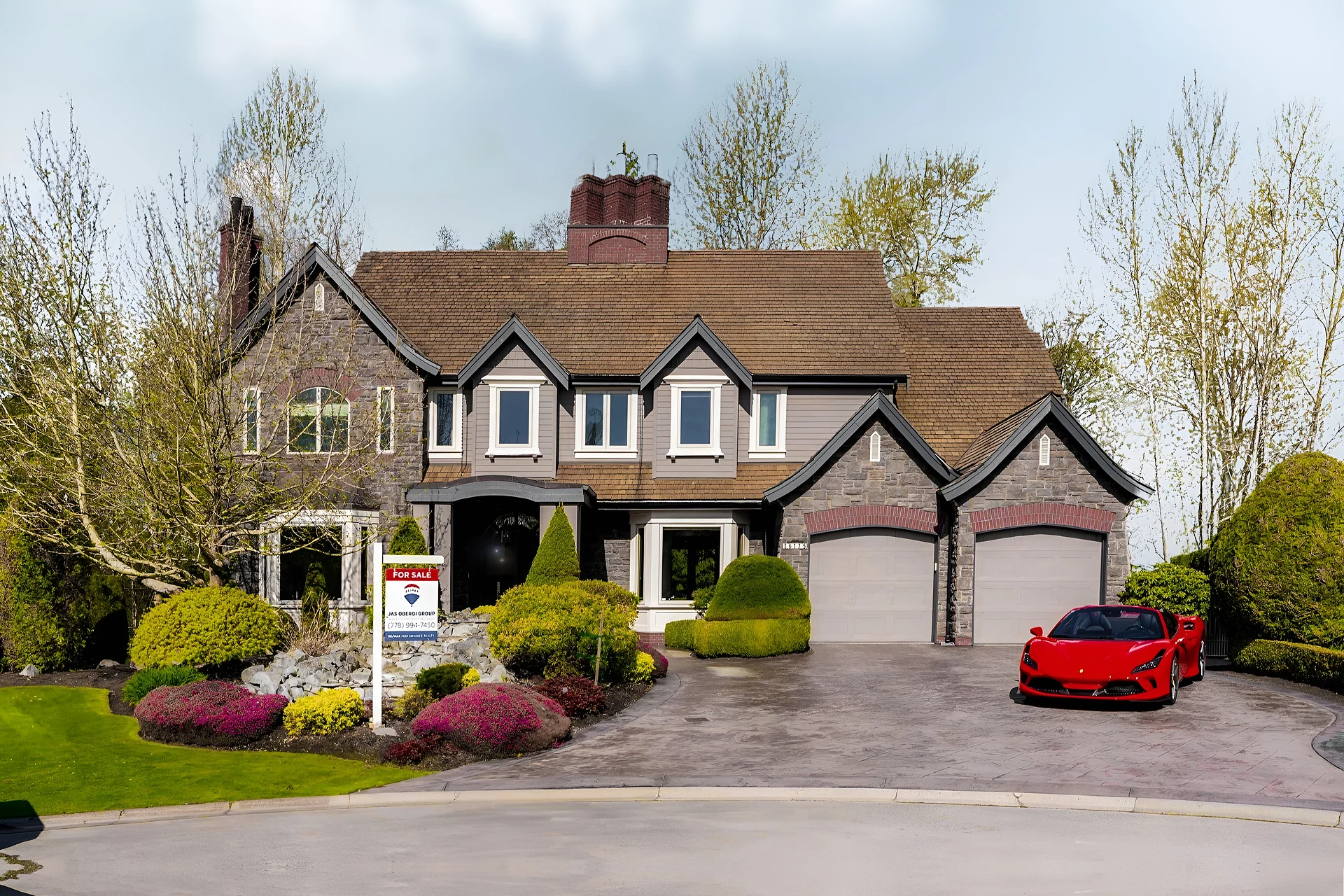 Large stone-and-shingle two-storey house with double garage, landscaped garden, For Sale sign and a red sports car in the driveway