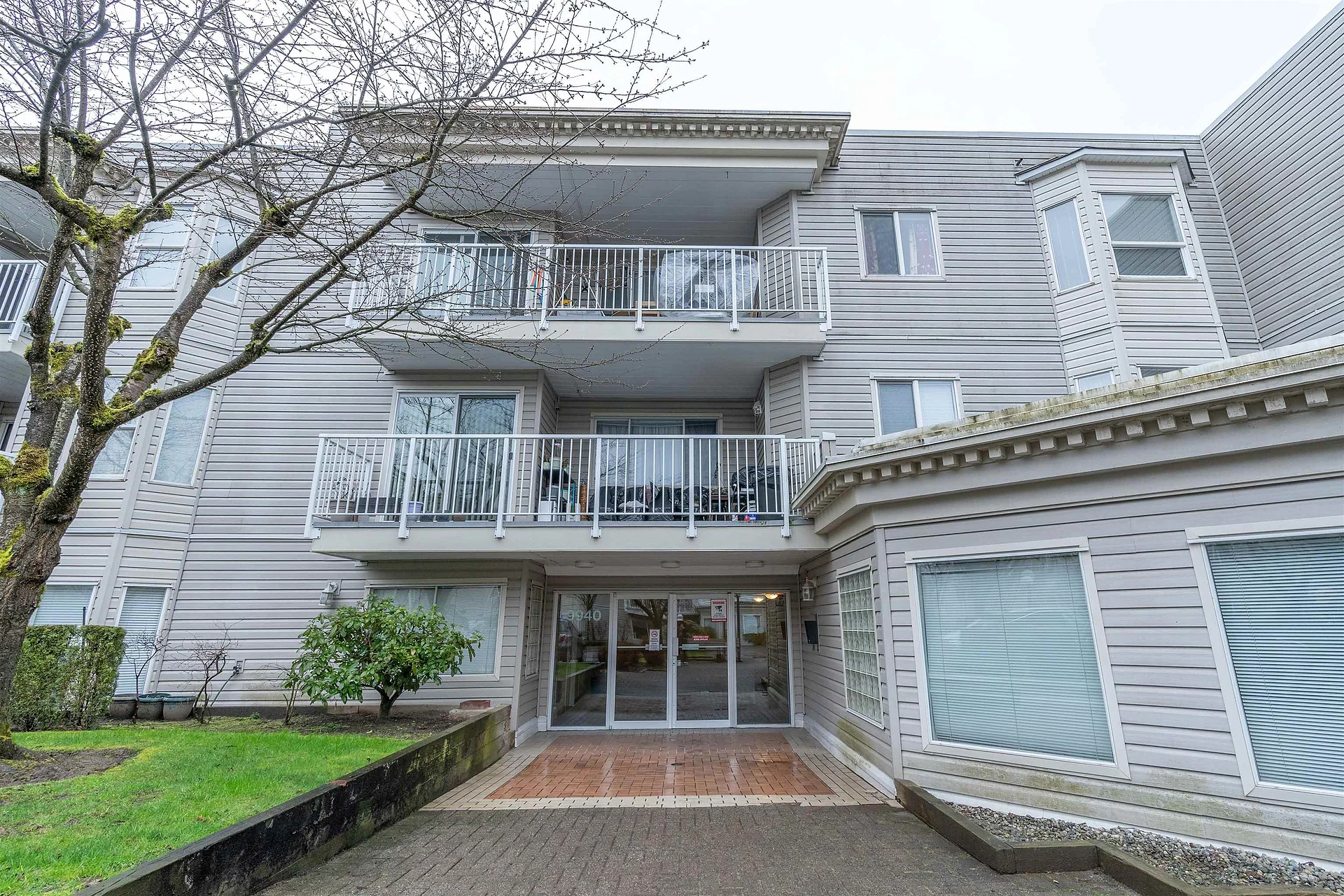 Three-storey low-rise condo building with balconies and glass entrance doors
