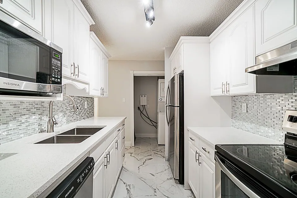Narrow white kitchen with a mosaic backsplash